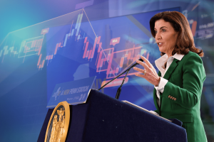 New York Gov. Kathy Hochul speaks at podium as stock market chart illustrates executive order banning insider trading on prediction markets.