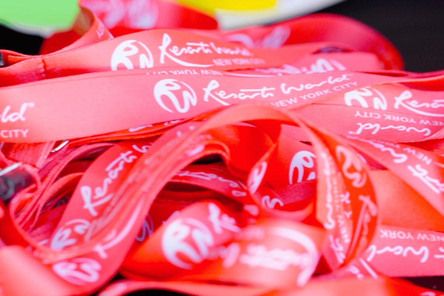 Close-up of red Resorts World New York City branded lanyards piled together at an event.