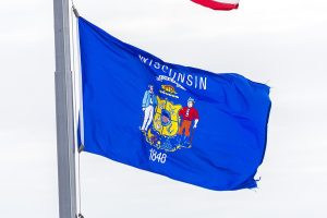 Wisconsin state flag flying from a flagpole.