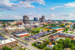 Aerial view of downtown Greensboro, North Carolina, featuring the city skyline, baseball stadium, commercial buildings, and surrounding neighborhoods. New Lumbee website explains upcoming tribal gaming amendment vote before June