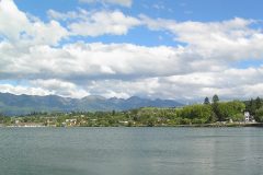 An image of Polson, Montana with a lake in the foreground and mountains in the background.