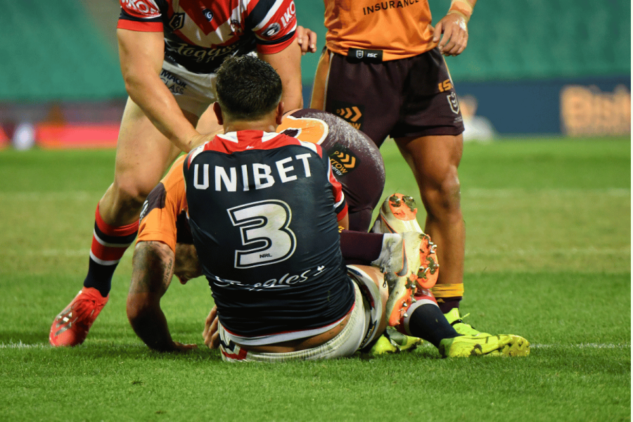 Sydney Roosters NRL player wearing a Unibet gambling logo on his jersey during a match against Brisbane Broncos
