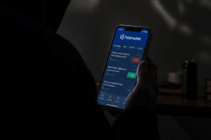 Person holding a smartphone displaying Polymarket prediction markets amid concerns over military bets and potential insider trading.