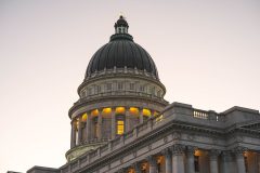 Utah State Capitol dome at dusk with lit windows and Corinthian columns