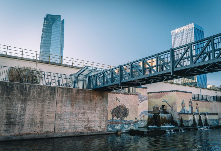 Oklahoma City canal with murals, a footbridge and downtown towers