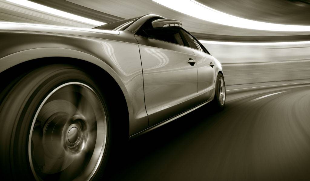 Silver car speeding in tunnel